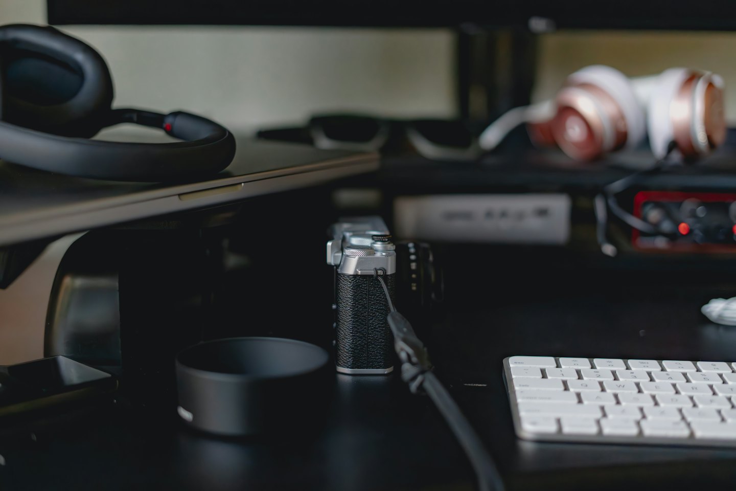 Modern office desk with a laptop keyboard and headphones.