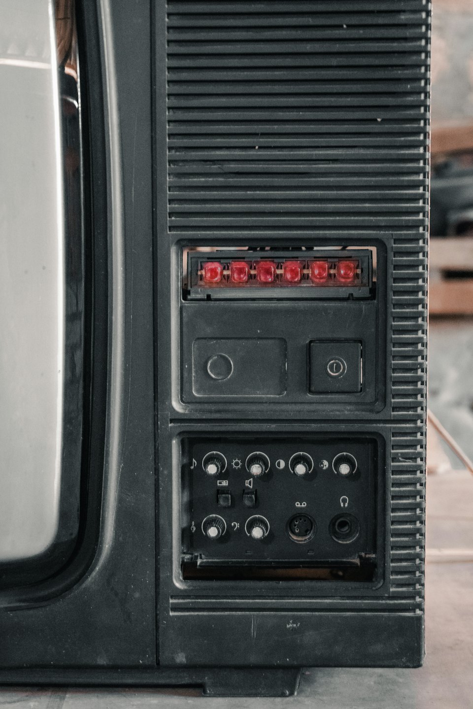 Vintage television side panel with red indicators and controls.