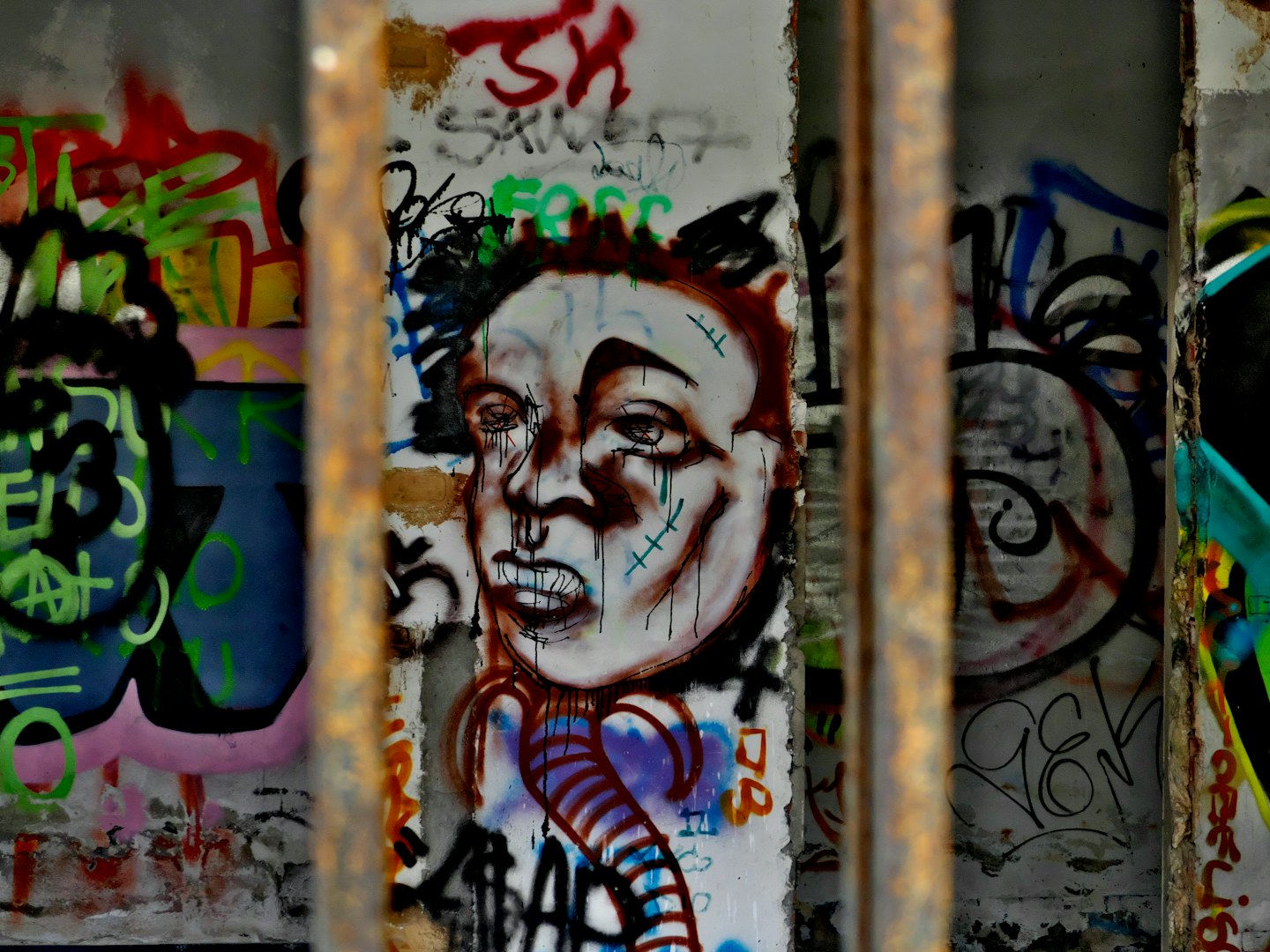 Graffiti art of a stylized face on a concrete wall.