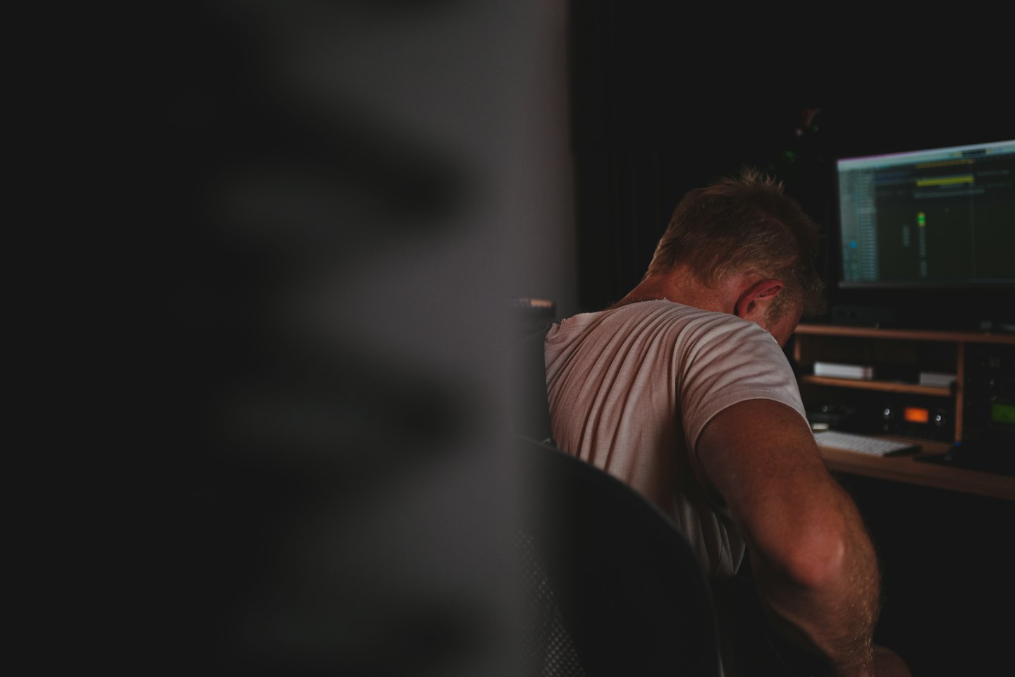 Audio engineer working on editing software at a computer station.